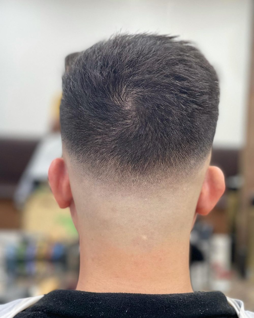 The back of a fade, graded from short at the neck up into the length on the crown.