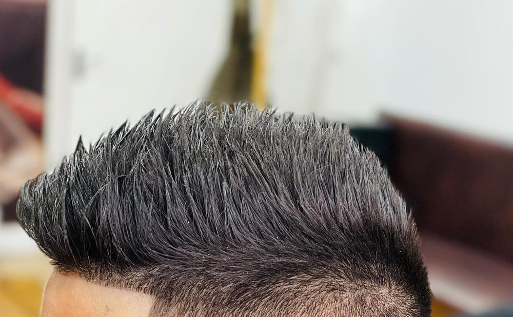 A spiked-up top on a child's haircut, with the sides faded in below it.